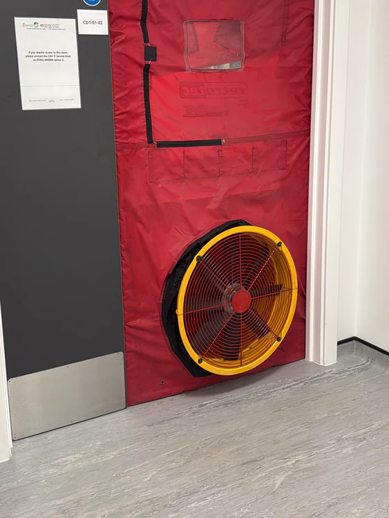 Retrotec door fan and red blanking panel fitted to a server room door during a room integrity test