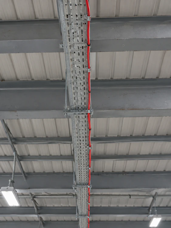 Linear heat detection cable fixed along a galvanised cable tray in an industrial roof