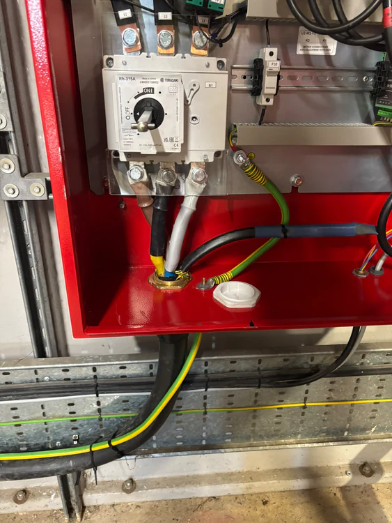 Fire pump control panel interior showing the main isolator, busbars and incoming supply terminations