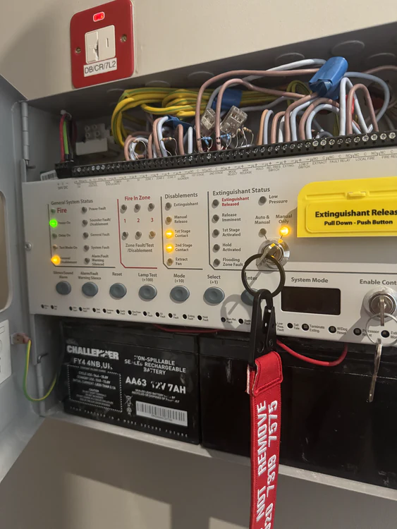Extinguishant release control panel opened for maintenance with standby batteries and disablement keys in place