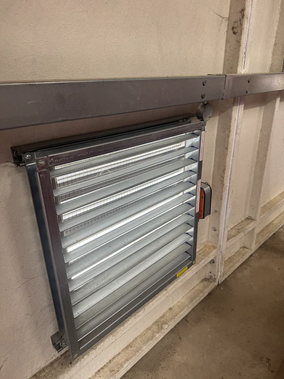 Fire damper being inspected and drop tested in a ceiling void