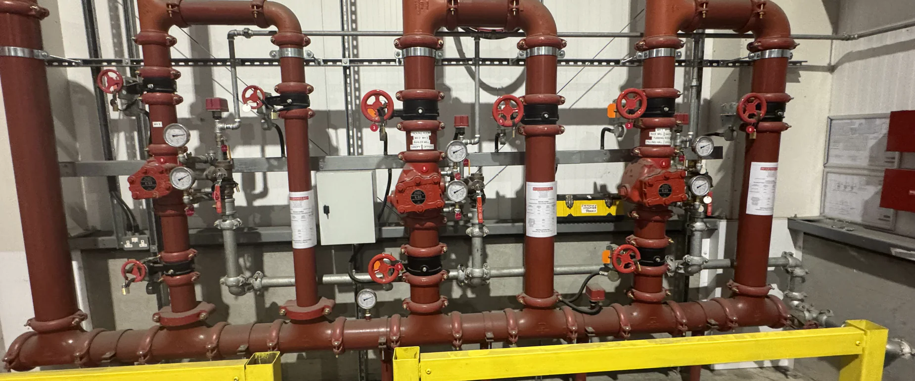 Bank of sprinkler installation control valve sets serving multiple zones in a warehouse riser room