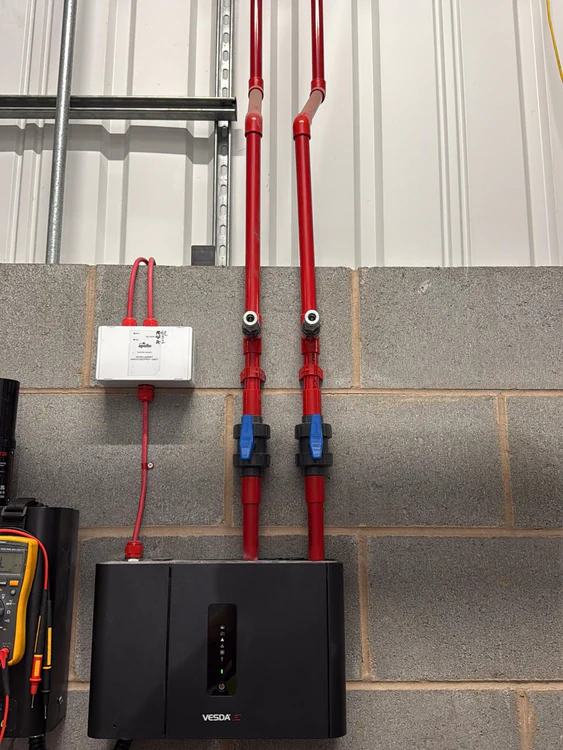 VESDA-E detector with red sampling pipework running up to the roof, installed by WSD